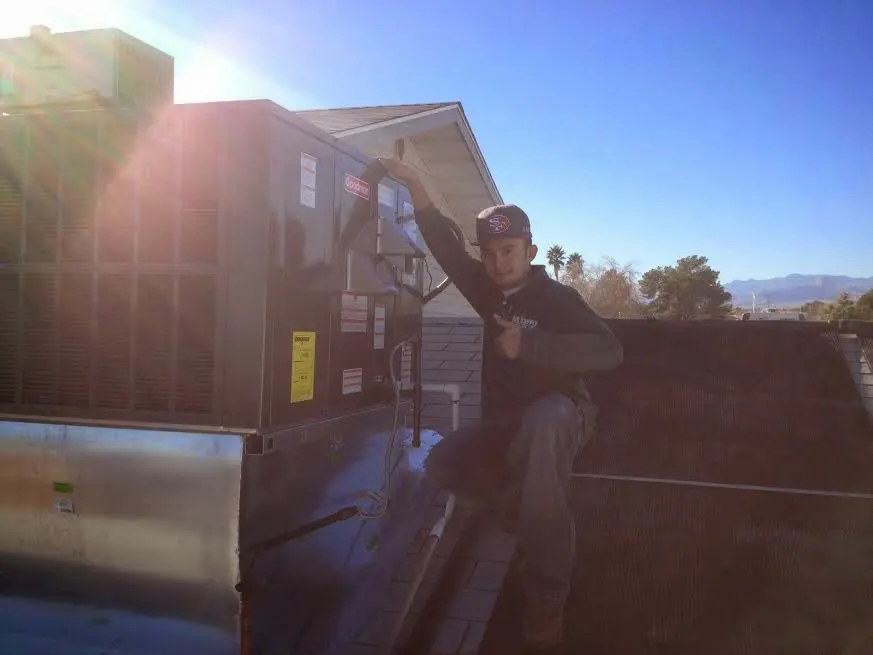 HVAC technician performing Heat Pump Repair on a rooftop unit in Kalispell